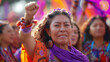 © Thitiporn - Empowered women in traditional attire raising fists at a colorful cultural festival, symbolizing strength