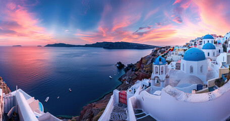 Wall Mural - The sun sets over the whitewashed buildings of Oia, Santorini with the deep blue sea in view.