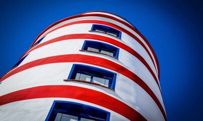 Poster - The colorful exterior of a building painted in red and white stripes with blue accents. AI.