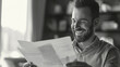 © Cadengo - A cheerful man reads a letter, the response to his job application or loan mortgage request. His face lights up with happiness and excitement as he absorbs the positive news