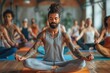 © Lens Legacy - Male yoga instructor with tattoos meditating peacefully in a yoga session
