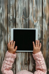 Poster - A young girl holds a tablet in front of a wooden wall, a learning or educational scene