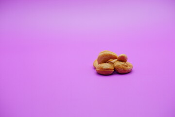 Wall Mural - cashew nuts isolated on a purple background