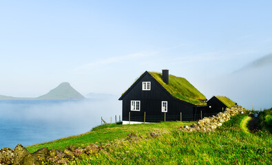 Wall Mural - black wooden faroese house with turf-top grass roof in the velbastadur village on streymoy island, f