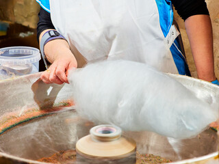 Wall Mural - Person making cotton candy at a street stall.