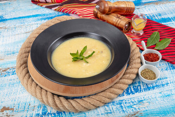 Wall Mural - Fish soup in a bowl. Fish soup with cream, sauces, lemon, herbs and croutons on wooden background.