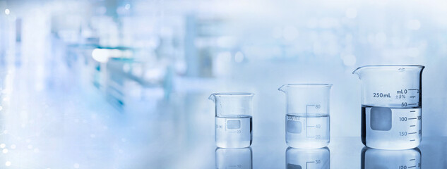 Wall Mural - beakers with water in chemistry science lab banner background