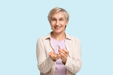 Poster - Mature woman with hearing aid on blue background