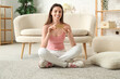 © Pixel-Shot - Beautiful young woman with birth control pills sitting on carpet in living room
