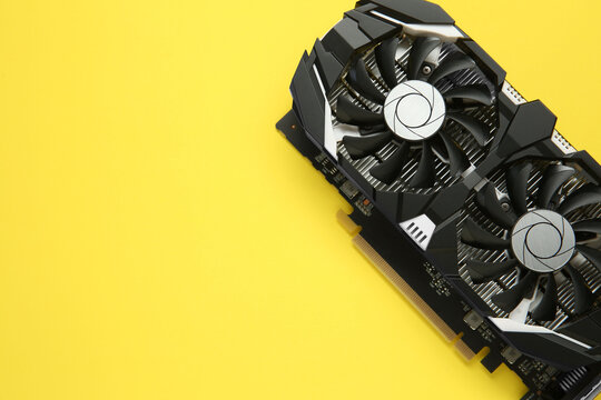 Computer graphics card on yellow background, top view. Space for text