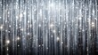 © Wanlop - Luxurious silver curtain backdrop with glittering rain-like effects, perfect for new year or christmas celebrations, with ample copy space for festive messages or designs.