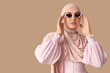 © Pixel-Shot - Stylish Muslim woman in sunglasses on beige background