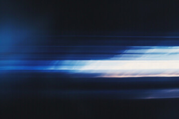 Poster - Grainy abstract light streaks in blue and white on a dark background, creating a sense of motion and speed for dynamic and modern design projects.
