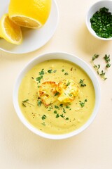 Wall Mural - Cauliflower cheese soup in bowl over light background