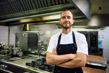 Wall Mural - Portrait of confident cook in  kitchen in restaurant looking at camera.