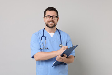 Canvas Print - Smiling doctor with clipboard on light grey background