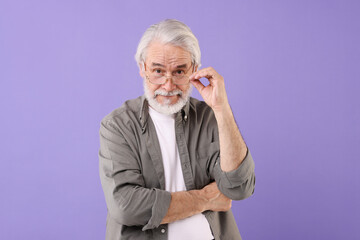 Wall Mural - Portrait of stylish grandpa with glasses on purple background