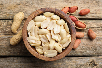 Wall Mural - Fresh peanuts in bowl on wooden table, top view