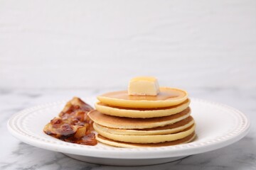 Wall Mural - Delicious pancakes with butter, maple syrup and fried bacon on white marble table