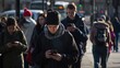 © MYDAYcontent - A group of people walk down a busy city street, all focused on their smartphones. This image captures the ubiquitous nature of mobile technology in modern society.