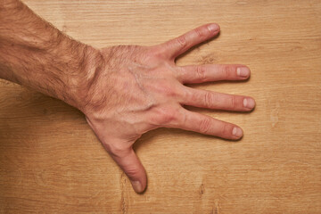 Wide open male hand on the floor.