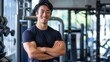© gn8 - Confident Asian Male Fitness Trainer Smiling at Gym with Crossed Arms, Encouraging Healthy Lifestyle and Physical Fitness Goals