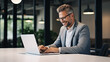 © Наталья Сивак - Smiling Businessman Working on Laptop in Modern Office