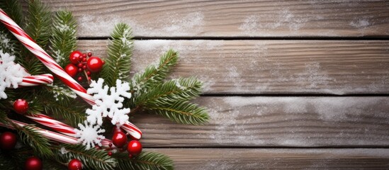 Poster - Seasonal Christmas flat lay with white lace doily candy canes and fir branches with snow on wooden copy space background