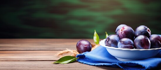 Wall Mural - Fresh ripe blue plums on plate wooden table with napkin. copy space available