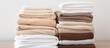 © Gular - home textiles A stack of towels lies on a white bed. copy space available