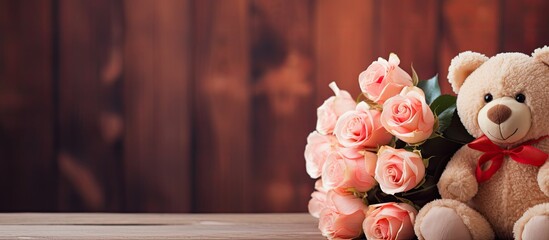 Wall Mural - A cute teddy bear a bouquet of roses and a card are elegantly displayed on a wooden background providing an ideal copy space image