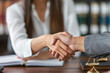 © Emanuel - Female lawyer or notary shaking hands with a client in her office, representing legal services and agreements