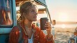 © Joyce - A female holding a coffee cup by vintage camper van at sea beach in summer vacation