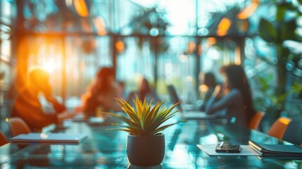 A group of people are sitting around a table with a potted plant in the middle