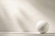 © Mr. Music - A white sphere sits on a white background, with sunbeams reflecting off the wall behind it.