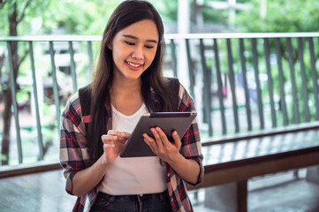 Wall Mural - woman is smiling while holding a tablet