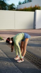 Wall Mural - A woman is running outdoors, wearing headphones to listen to music while exercising