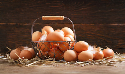 Wall Mural - basket of chicken eggs on a wooden background