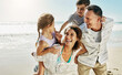 © peopleimages.com - Beach, family and parents piggy back for holiday, fun and together with children for Australia adventure. Summer, ocean and vacation afternoon with happy mother, father and kids laughing in nature