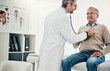 © peopleimages.com - Checkup, man and doctor in office with stethoscope, help or advice in health insurance. Clinic, senior patient and medical professional on bed with support, heart rate and healthcare for hypertension
