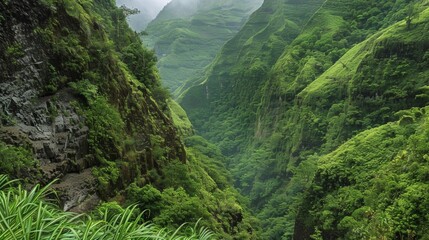 Wall Mural - a lush green valley marked by unstable cliffs and steep slopes prone to frequent landslides.