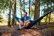 © baranq - Happy man sitting in hammock relaxing