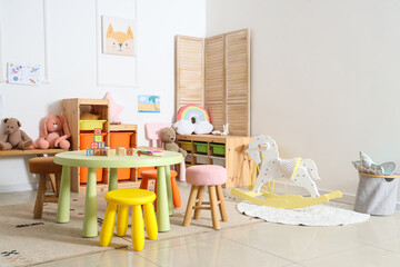 Sticker - Interior of light playroom with toys in kindergarten