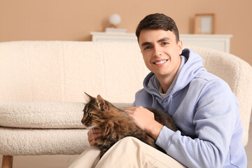 Wall Mural - Young man holding cute cat at home