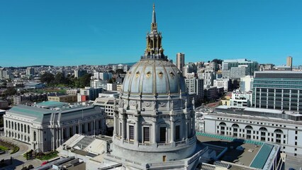 Wall Mural - descending aerial footage of San Francisco City Hall with office buildings and skyscrapers in the city skyline and cars on the street with blue sky in San Francisco California USA