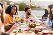 © Xavier Lorenzo - Happy diverse group of friends enjoying dinner barbecue in summer at home terrace.