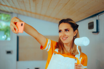 Woman Taking a Selfie with a Paint Roller Renovating her Home. Joyful repairwoman trying to remodel her house alone 
