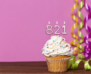 Birthday Cupcake With Candles Lit Forming The Number 821