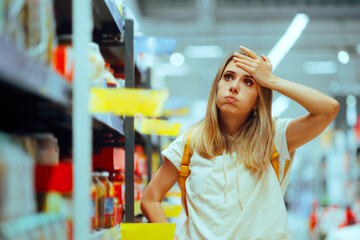 Stressed Woman Checking Inflated Prices in a Supermarket. Unhappy hypermarket shopper finding the hyperinflation exaggerated
