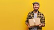 © Artlana - Delivery man holding parcel box on yellow background with copyspace for your text